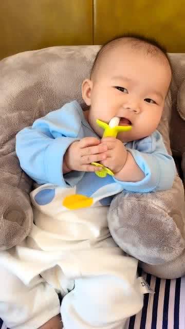 這個小寶寶真可愛,懶洋洋地倚在大象玩具上,看什么呢